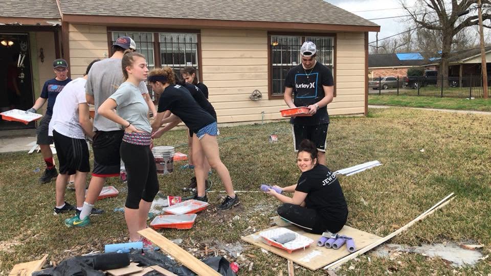 Teens in ‘Jew Crew’ shirts preparing paint rollers and trays outside a Houston home being restored over February school vacation.